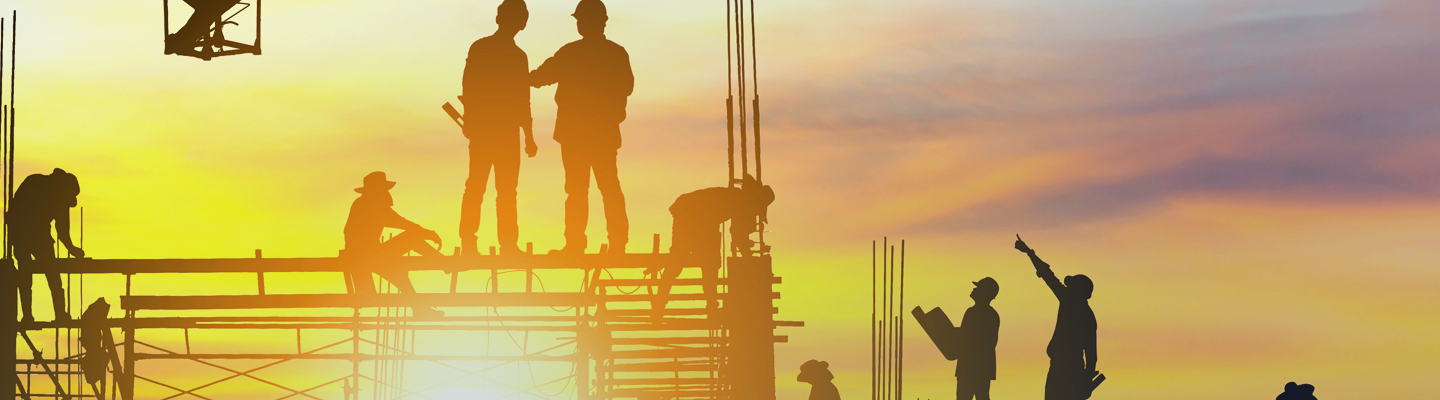Construction workers silhouette on building with sunset
